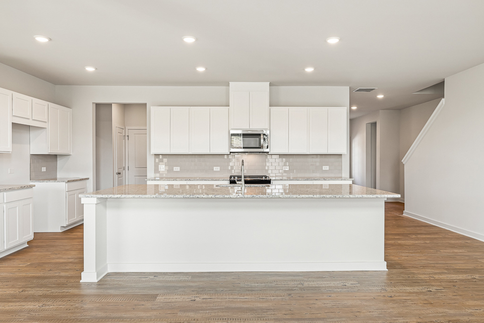 A kitchen with white cabinets.