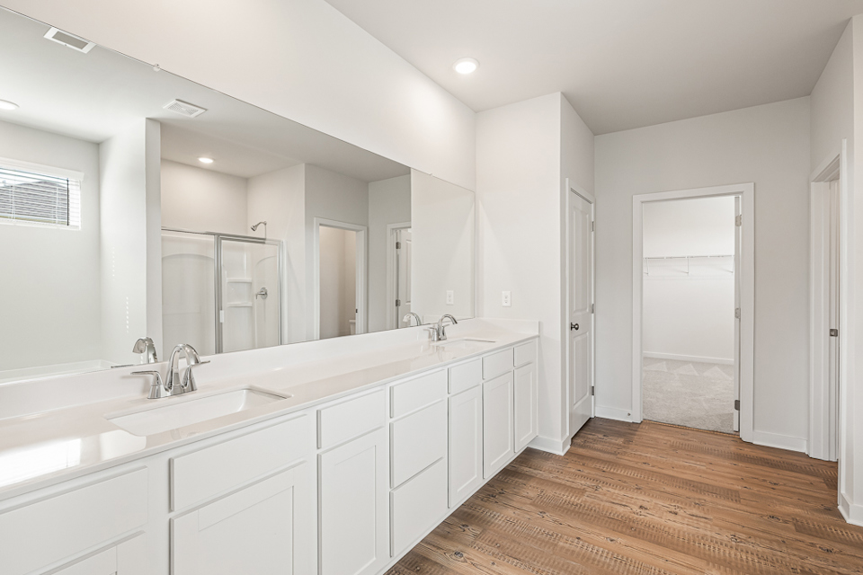 A bathroom with white cabinets.
