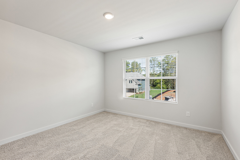 A room with a window and a carpet.