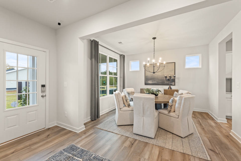 A living room with a white couch and a white rug.