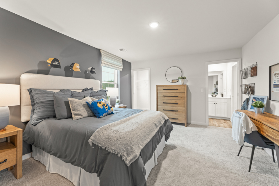 A bedroom with a bed and a desk.