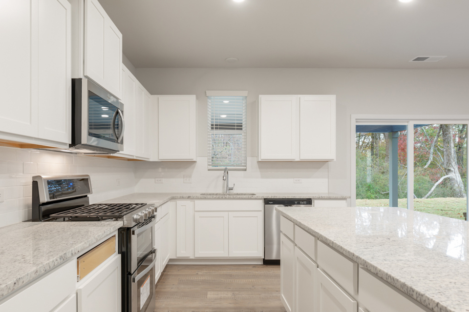 A kitchen with white cabinets.