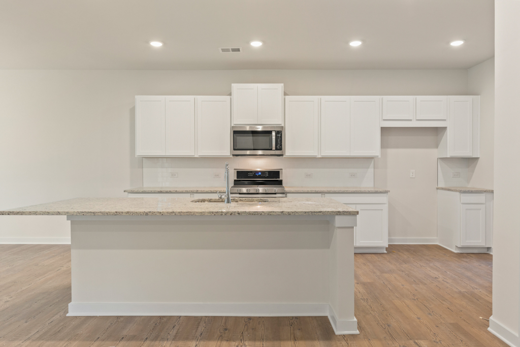 A kitchen with white cabinets.