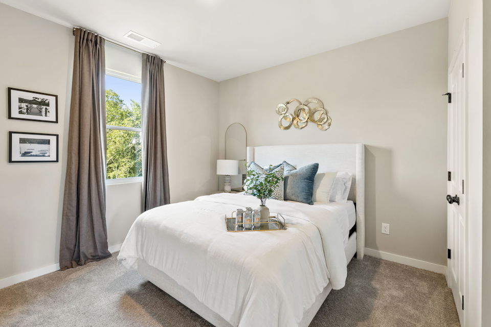 A bedroom with a bed and a mirror.