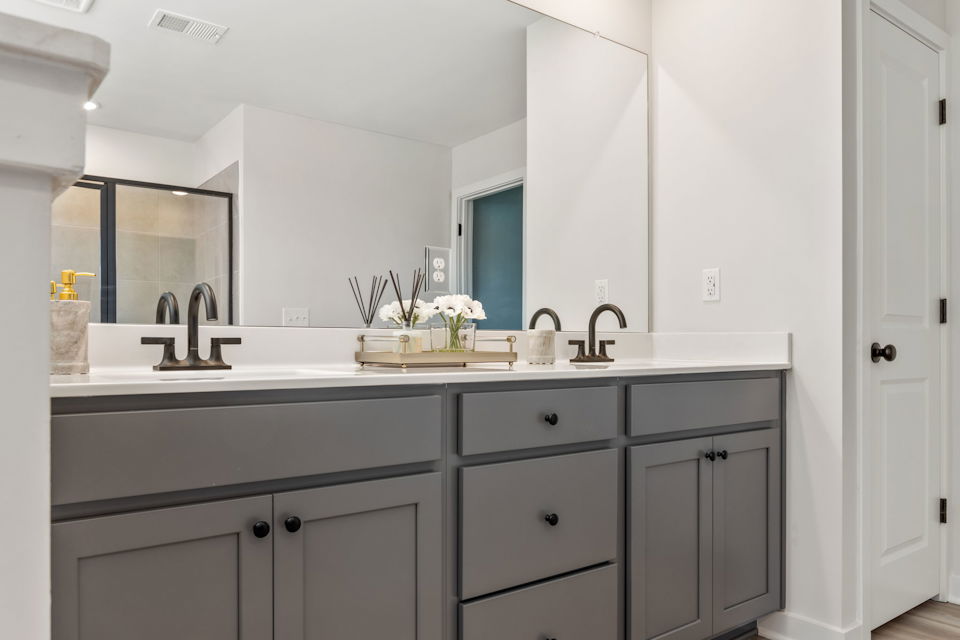 A bathroom with white cabinets.
