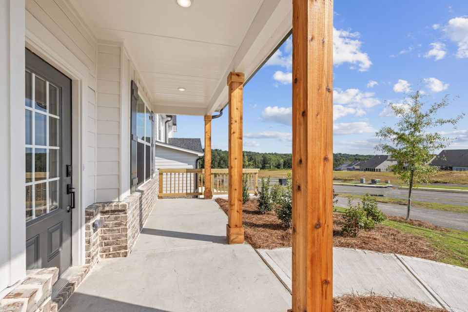 A house with a deck and a tree.