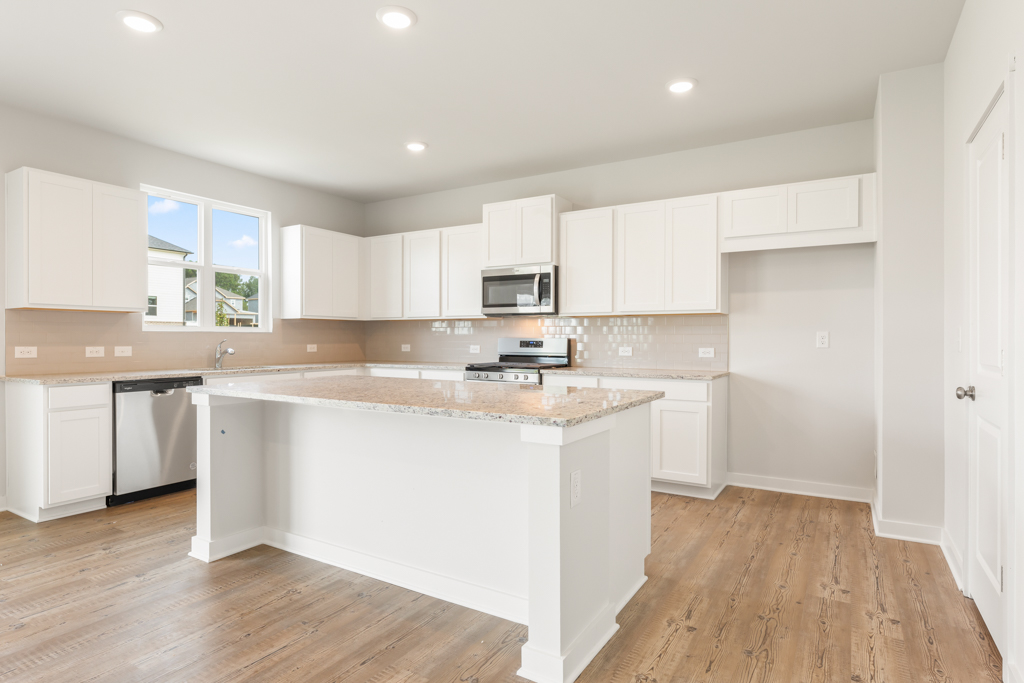A kitchen with white cabinets.