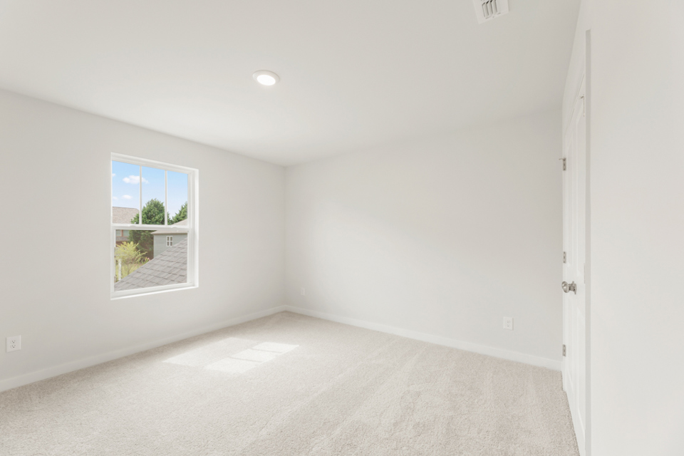 A room with a window and a carpet.