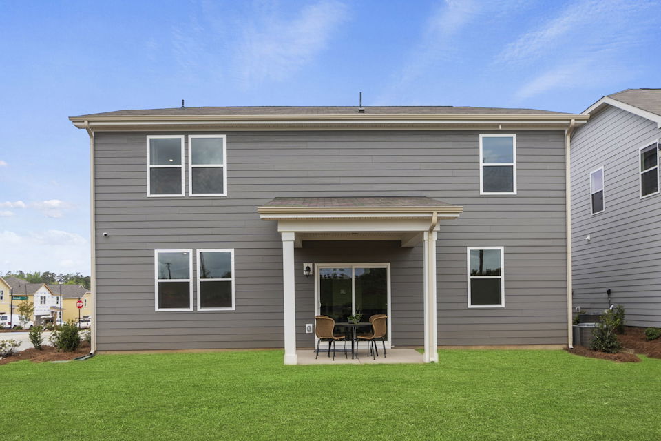 A house with a table and chairs in the front.