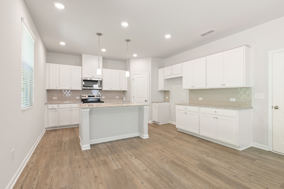 A kitchen with white cabinets.