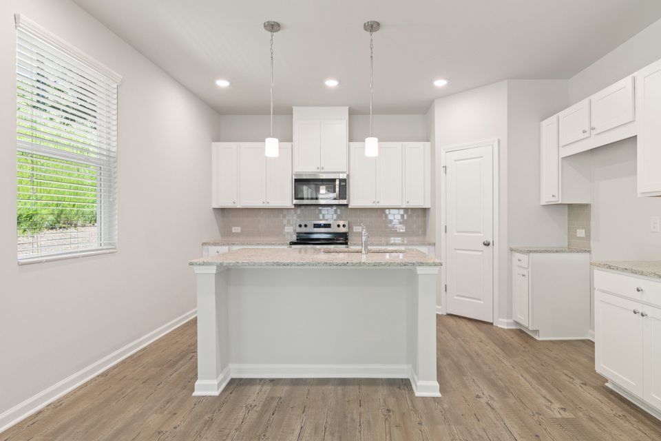 A kitchen with white cabinets.