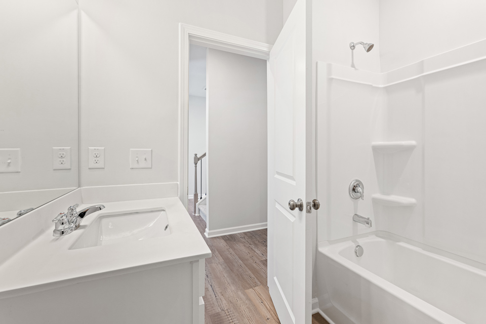 A bathroom with a tub sink and a shower.