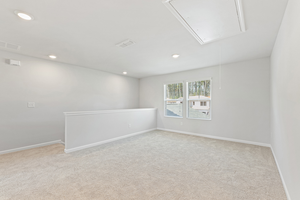 A room with a white wall and a window.