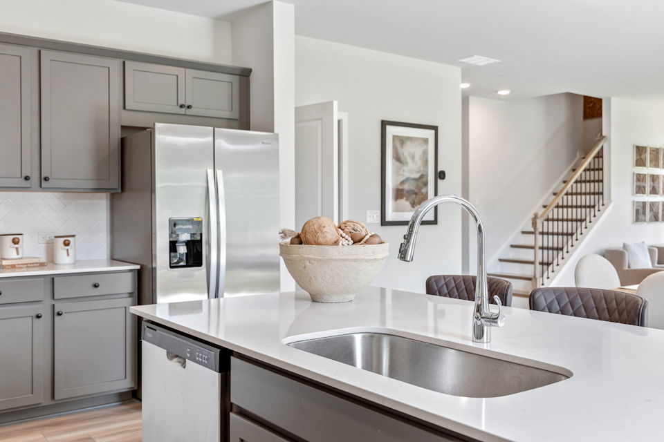 A kitchen with a sink and a refrigerator.
