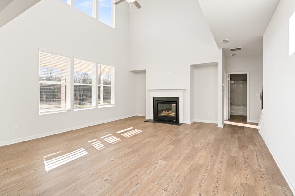 A room with a fireplace and wood floors.