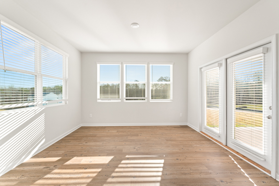 A room with windows and a wood floor.