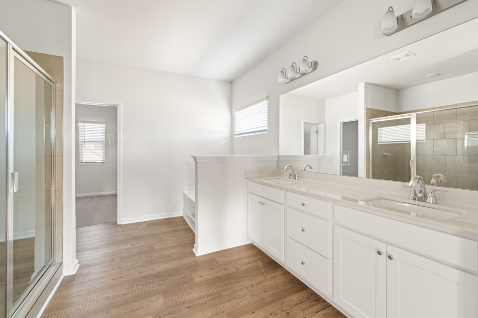 A bathroom with white cabinets.