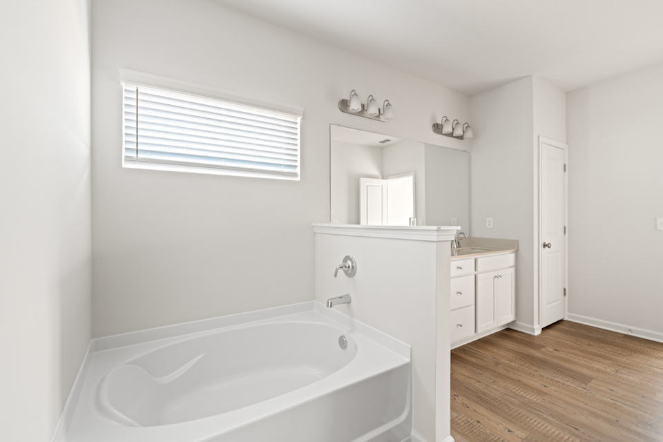 A bathroom with a tub and cabinets.