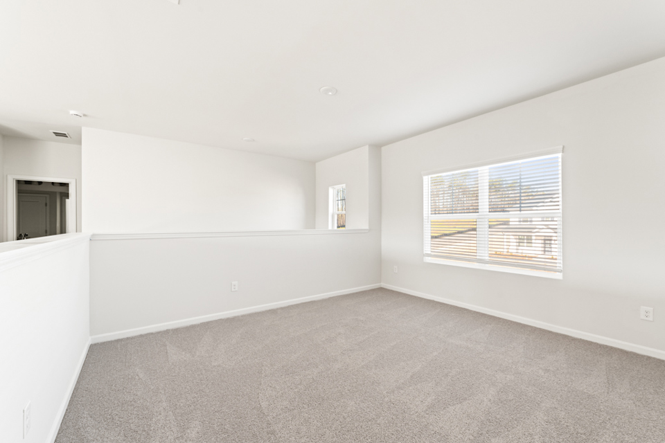 A room with a window and a rug.