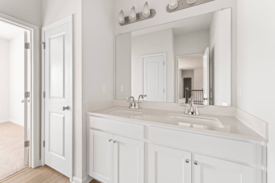 A bathroom with white cabinets.