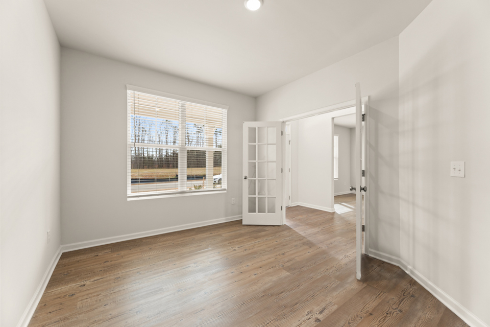 A room with a wood floor and a window.