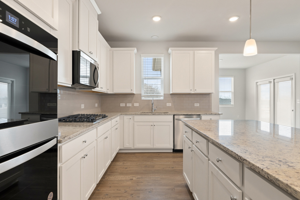 A kitchen with white cabinets.