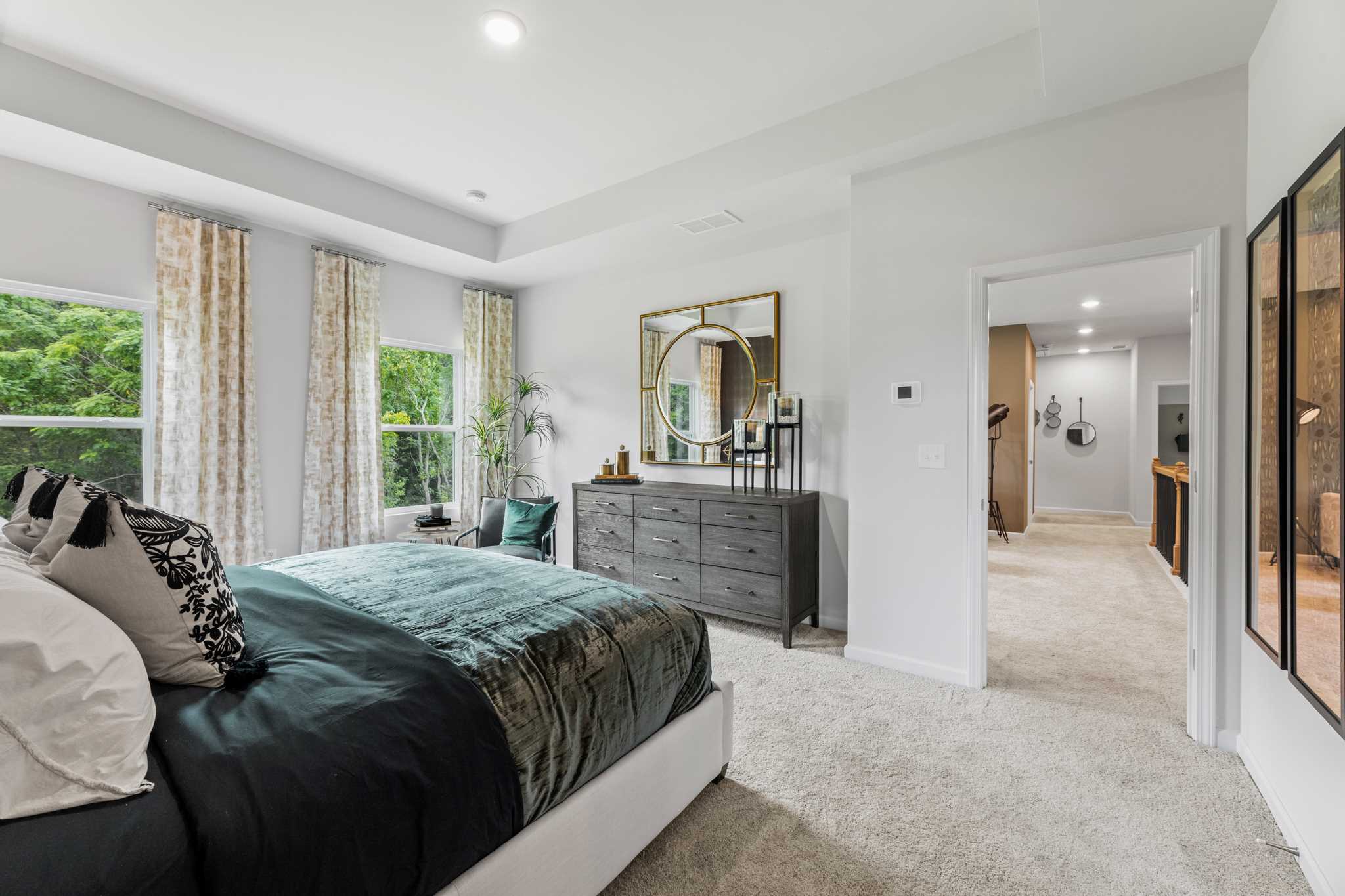 A bedroom with a large mirror.