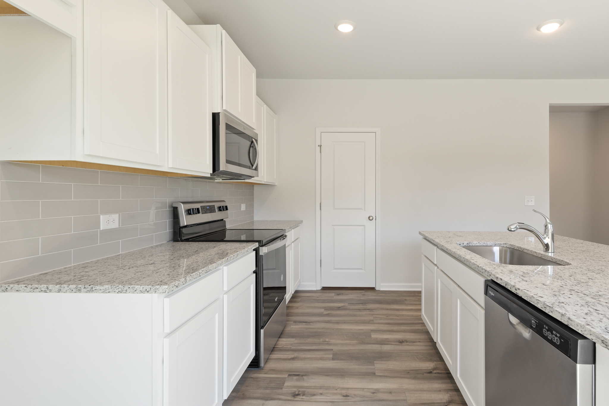 A kitchen with white cabinets.