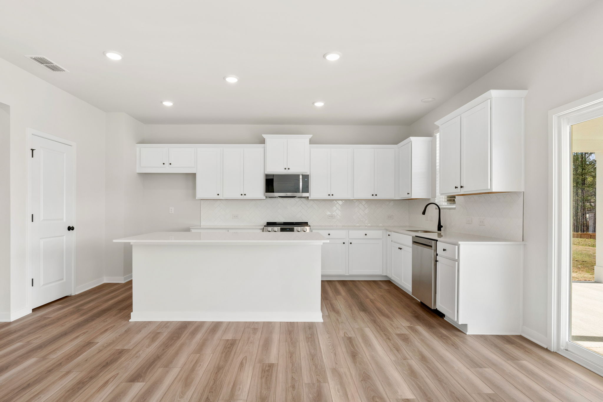A kitchen with white cabinets.