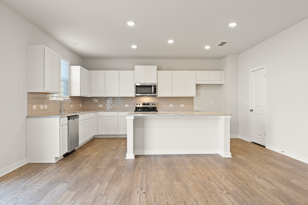 A kitchen with white cabinets.