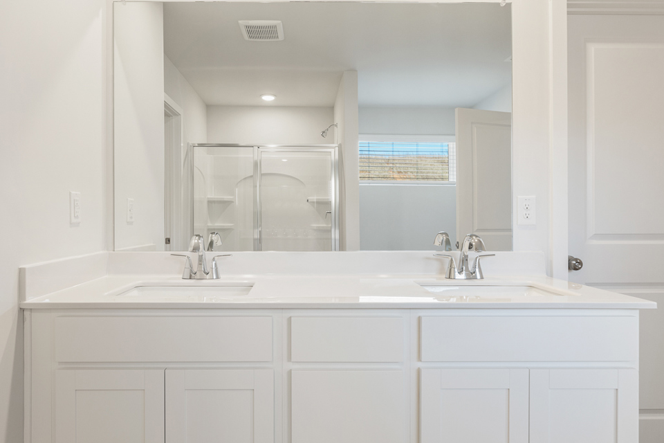 A bathroom with white cabinets.