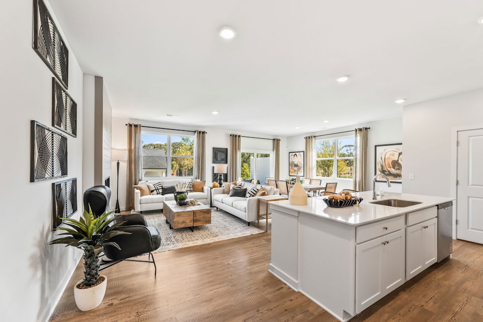 A large living room with a large kitchen and a large window.