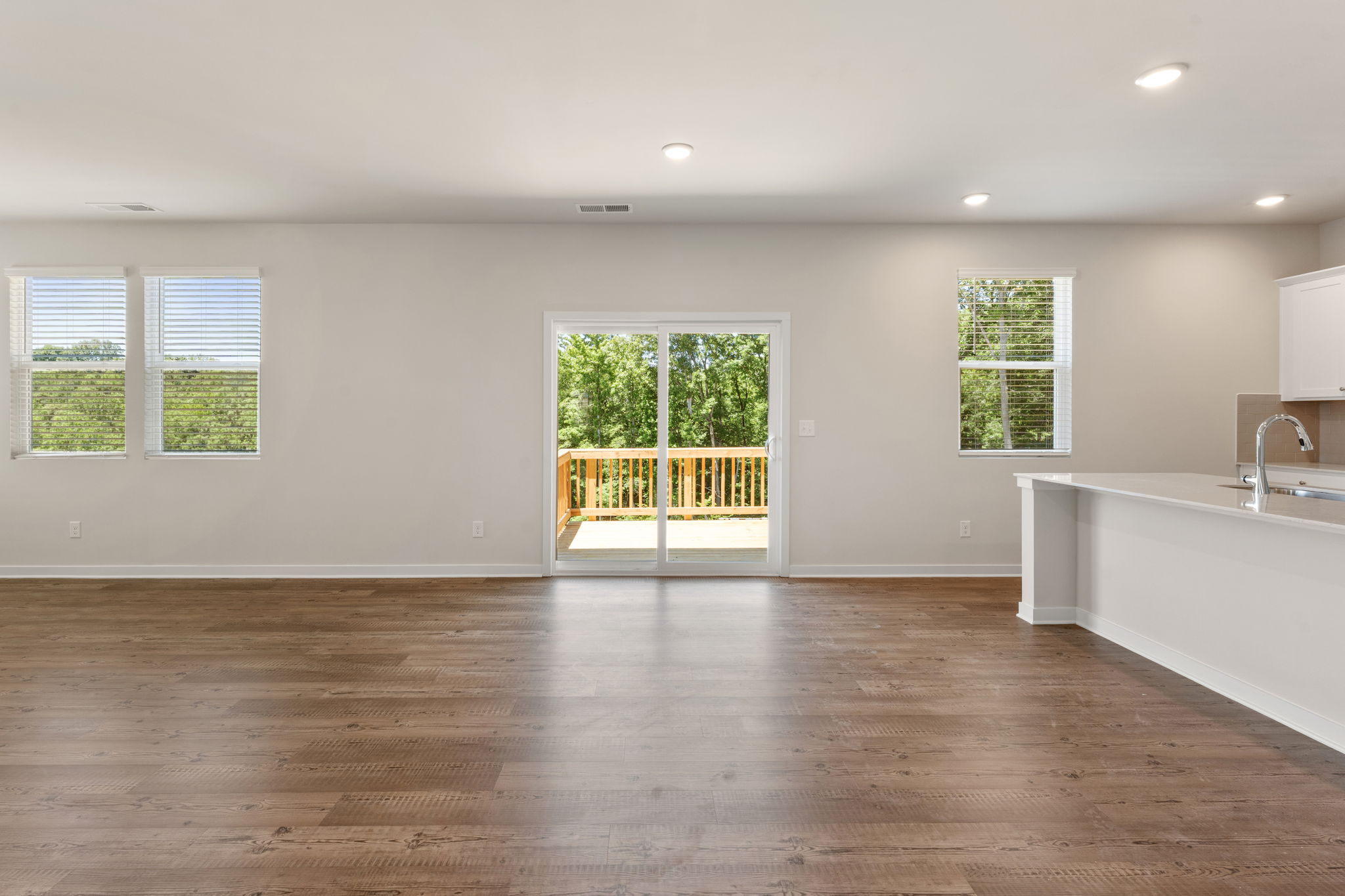 A large empty bathroom with a wood floor.