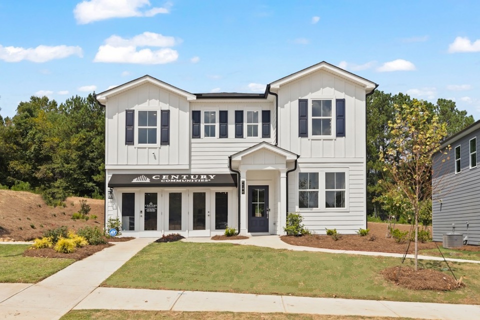 A white building with a lawn in front of it.