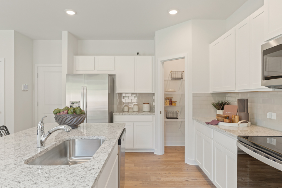 A kitchen with white cabinets.