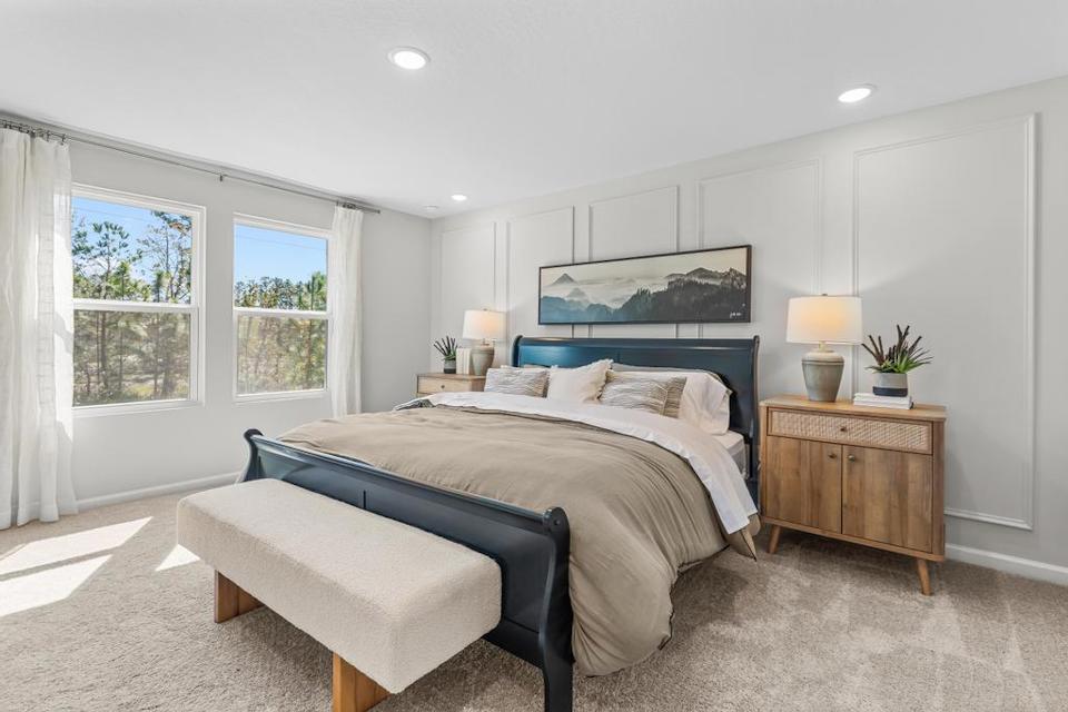 A bedroom with a bed and a bench.