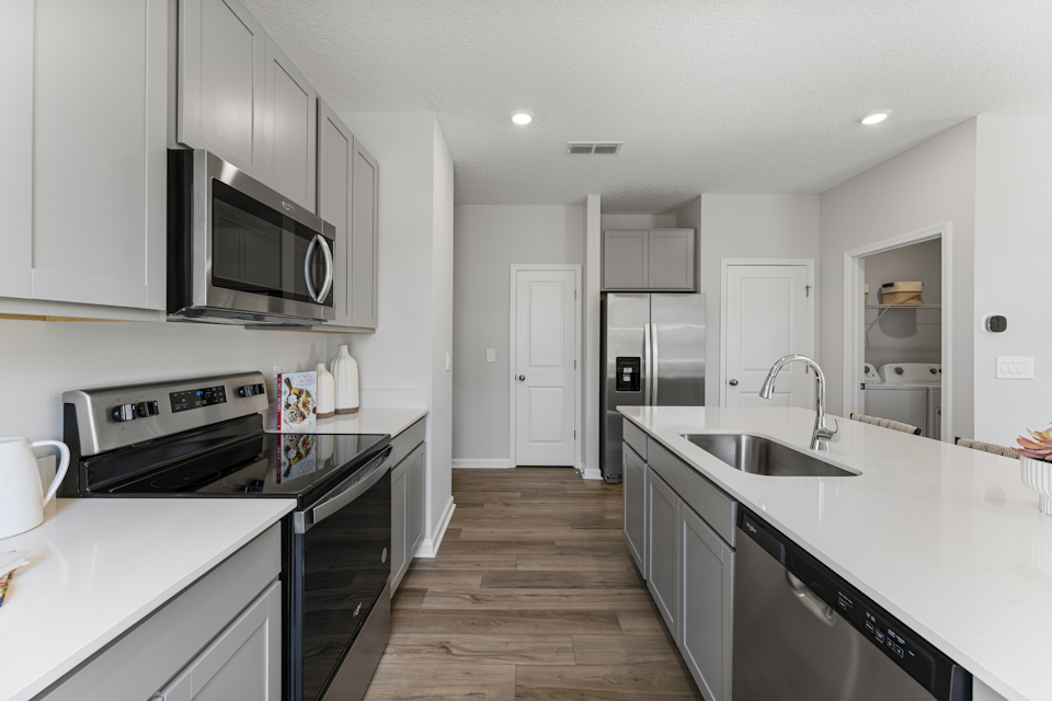 Sanibel Model Home Kitchen with White Quartz Counters at The Landings at Pecan Park in Jacksonville