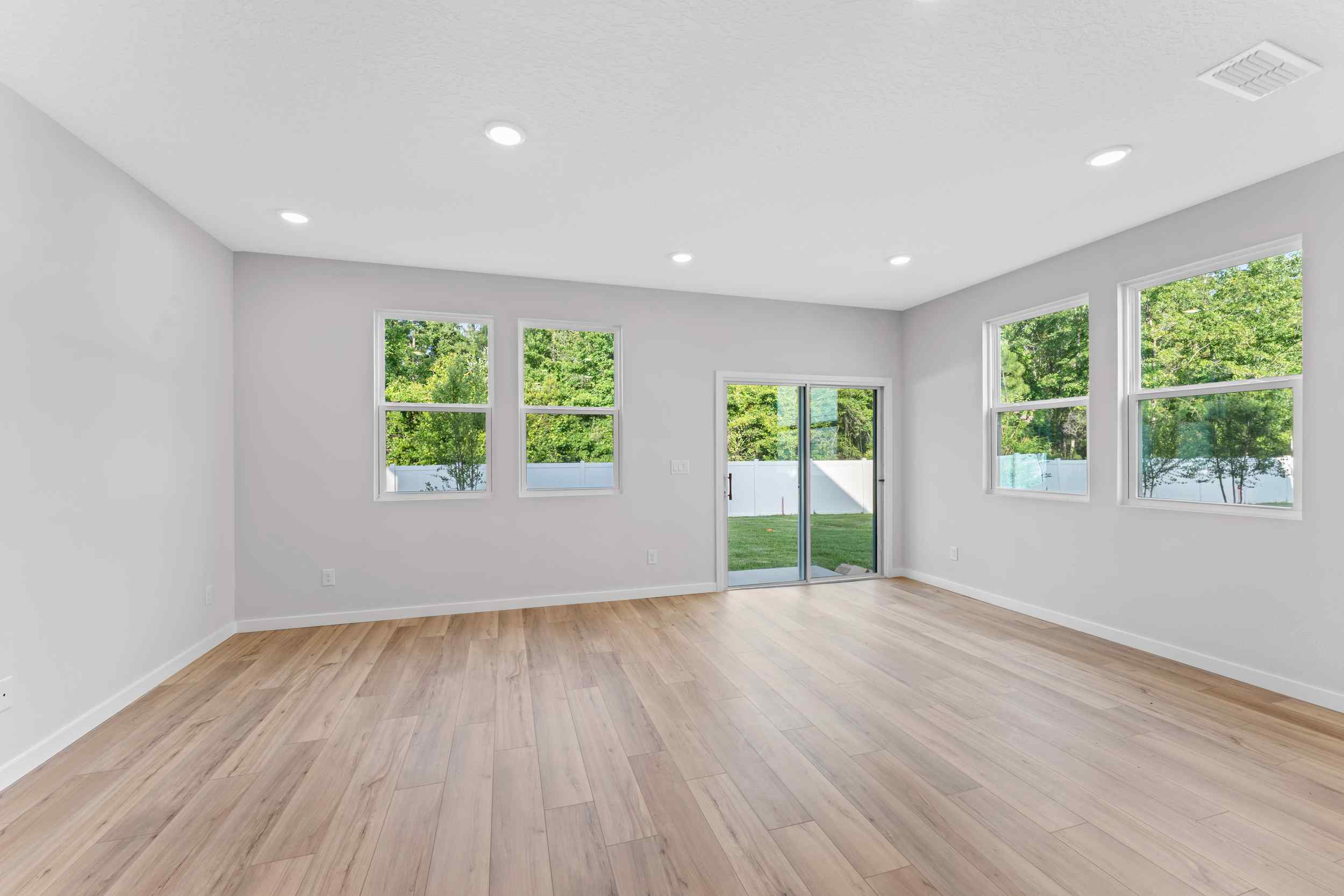 Davor Paired Home Empty Great Room with Windows at The Landings at Pecan Park in Jacksonville