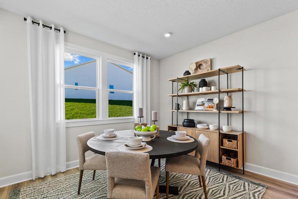 A dining room with a table and chairs.