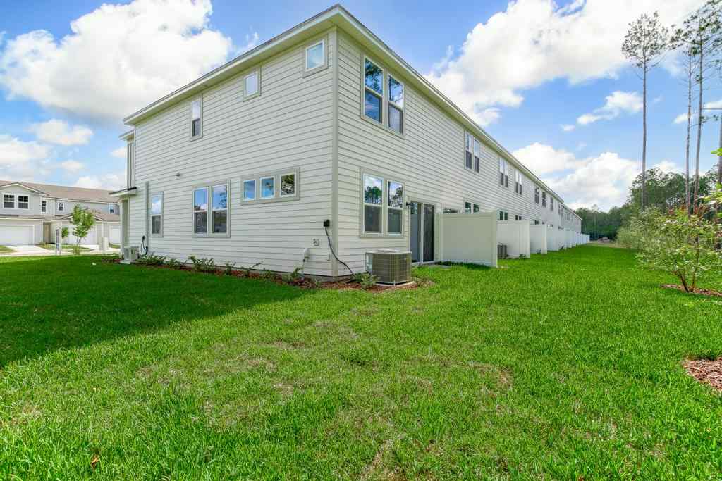 A white house with a green lawn.