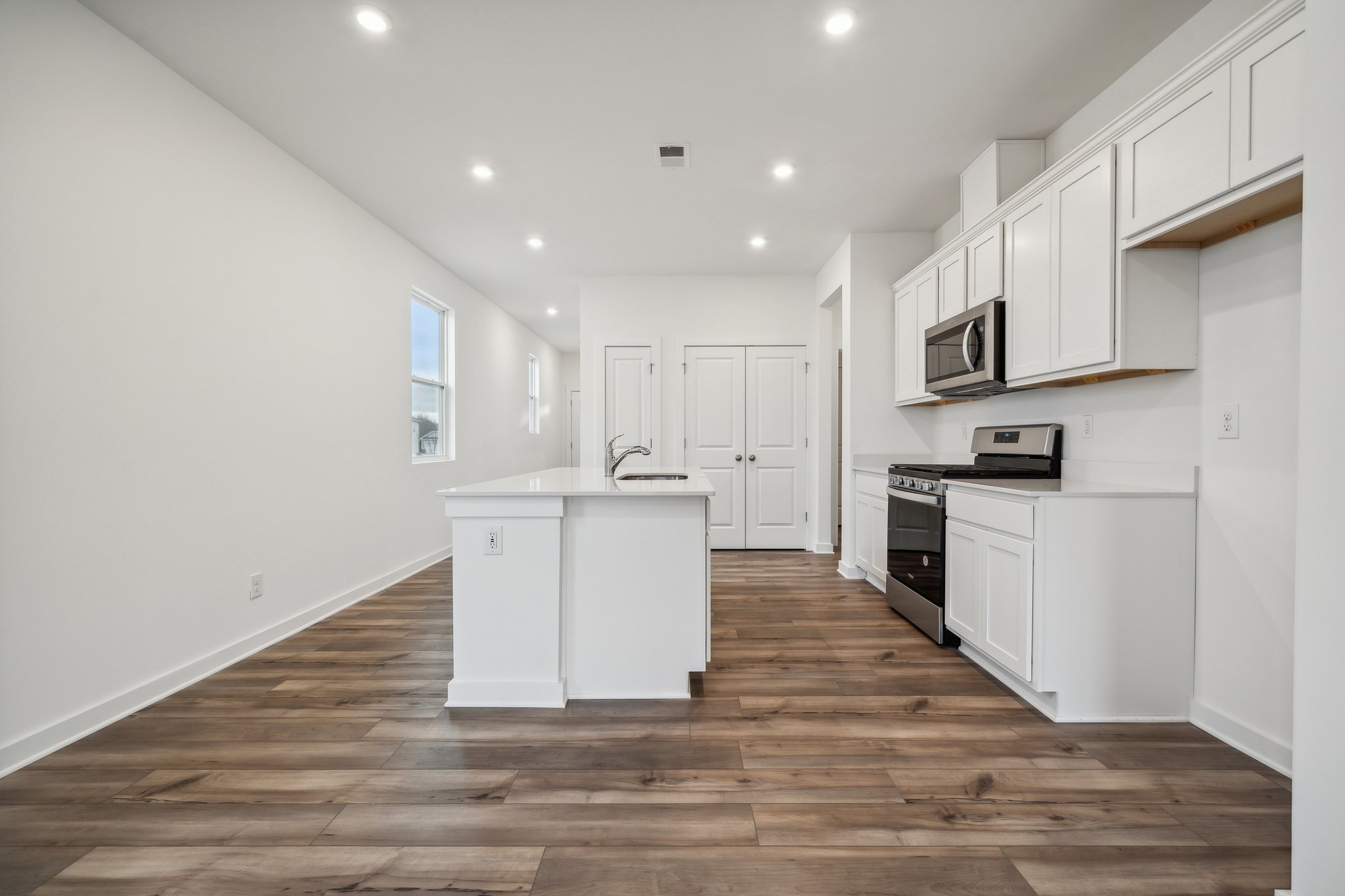 A kitchen with white cabinets.