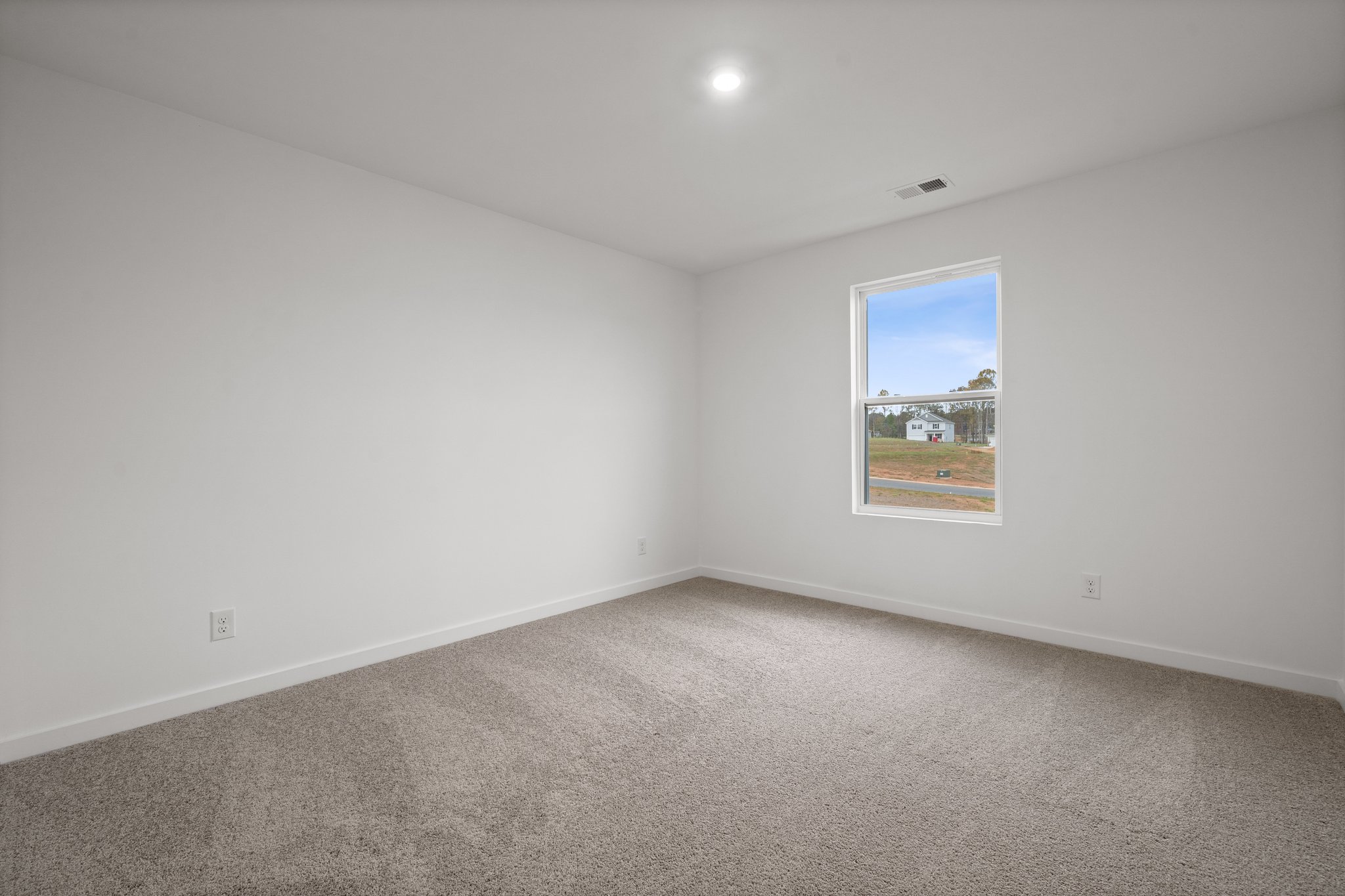 A room with a window and a carpet.
