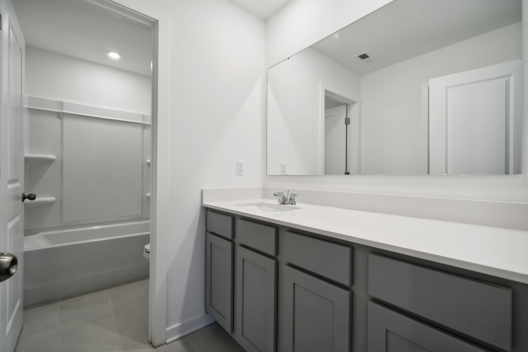 A bathroom with a sink and a shower unit.