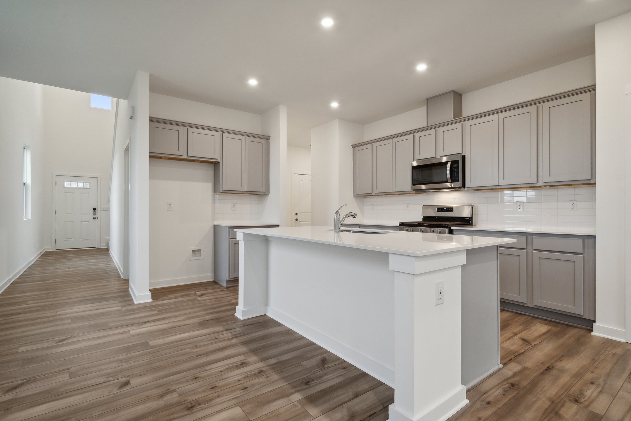 A kitchen with white cabinets.