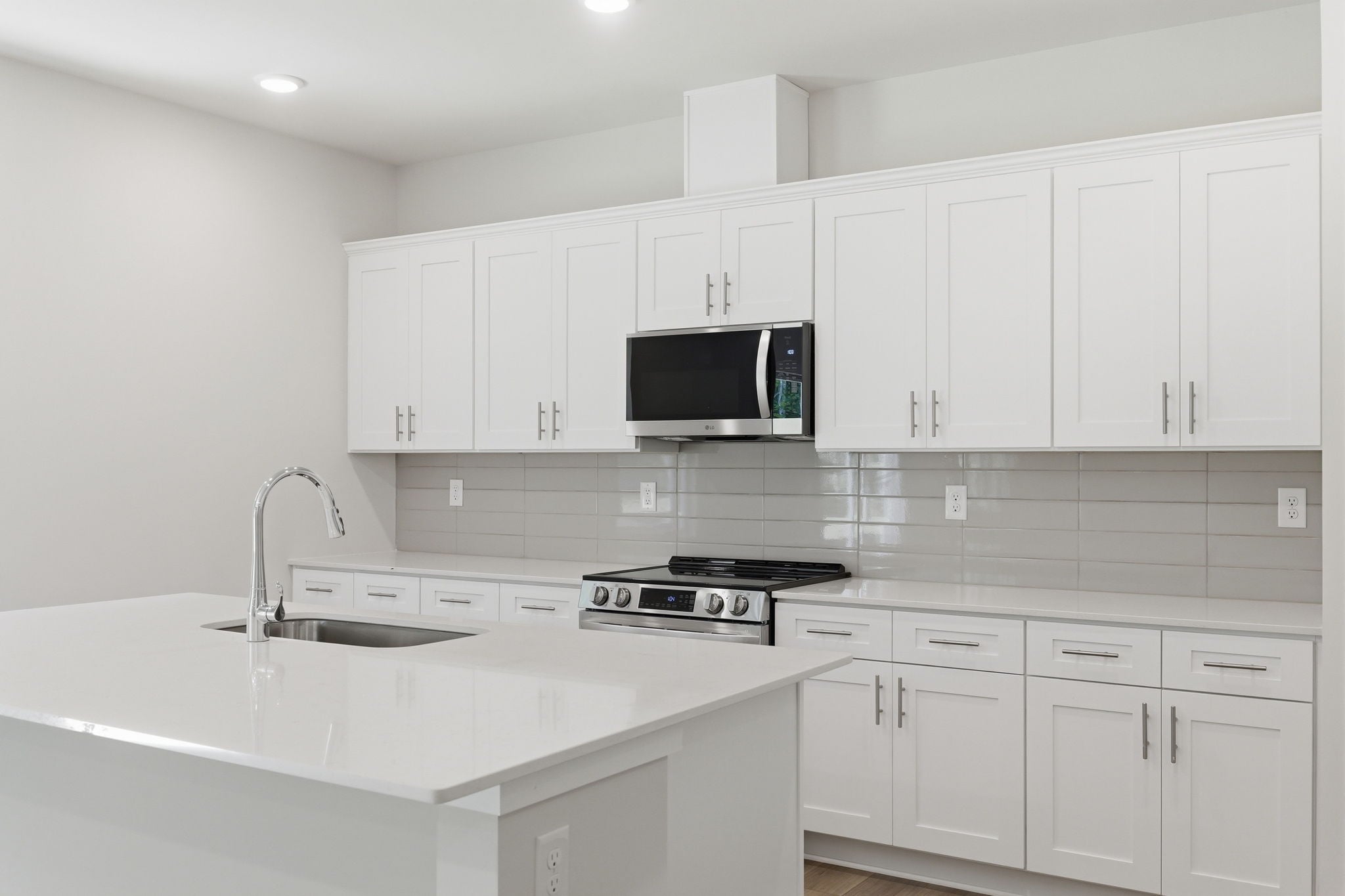 A kitchen with white cabinets.