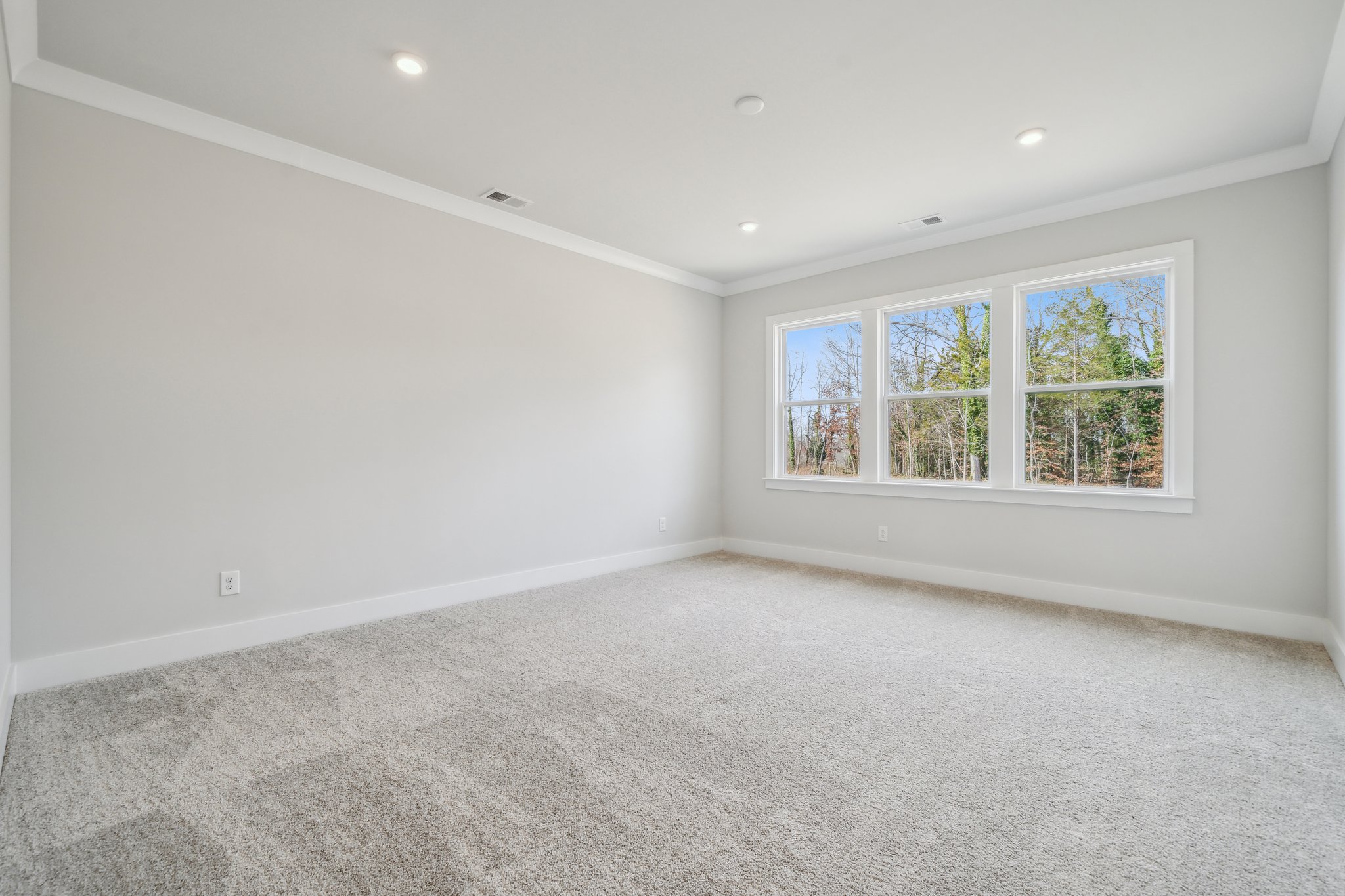A room with a window and a carpet.