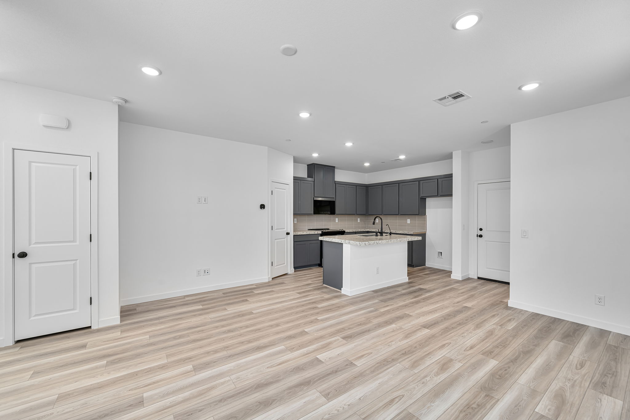 A large kitchen with black cabinets.