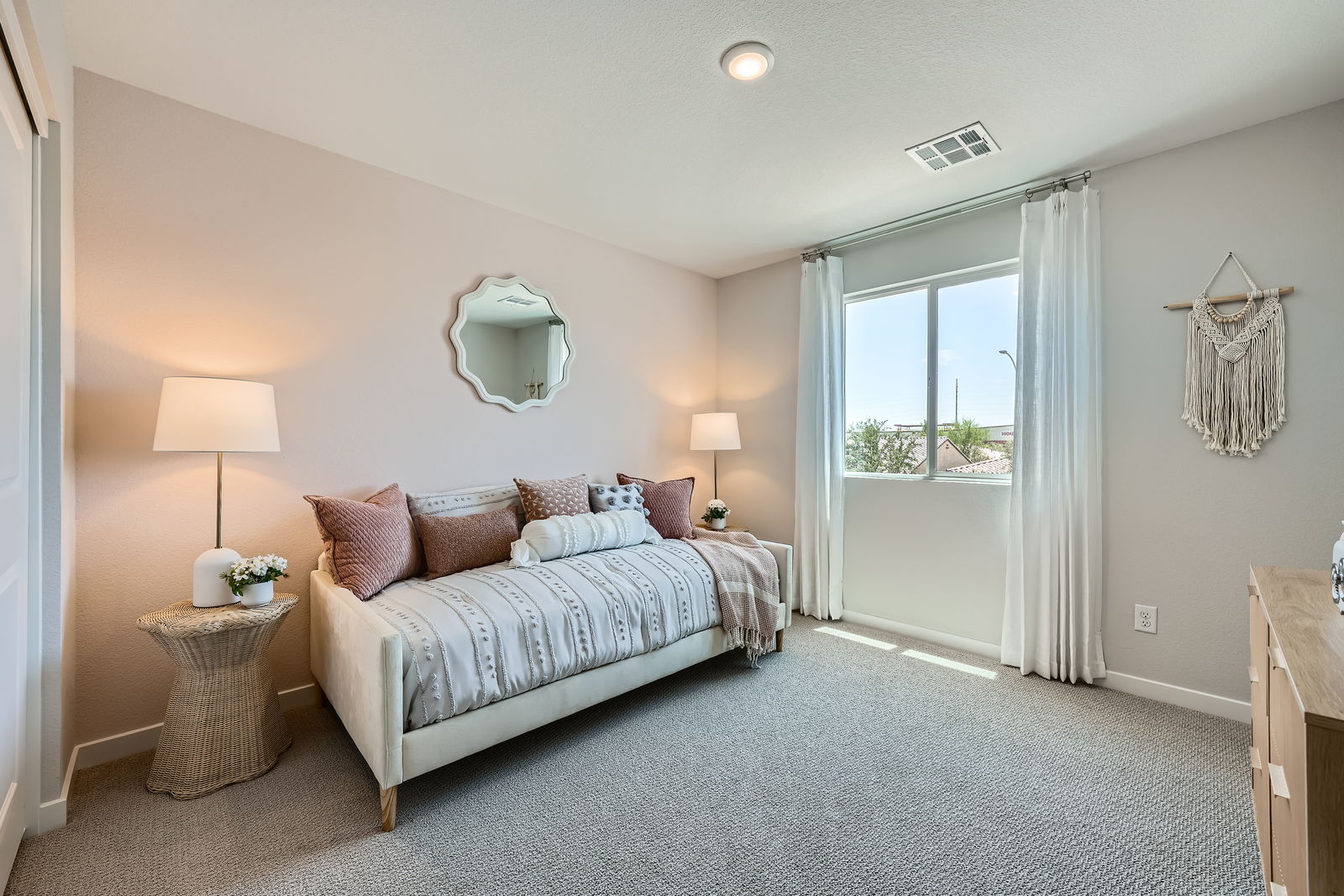 A bedroom with a bed and lamps.