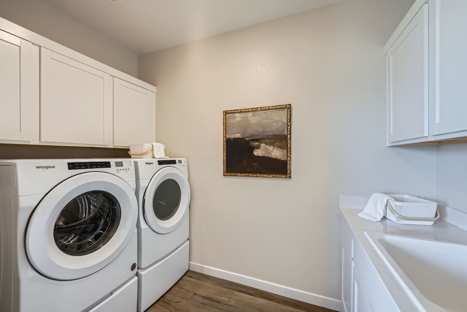 A room with white cabinets and a washer and dryer.