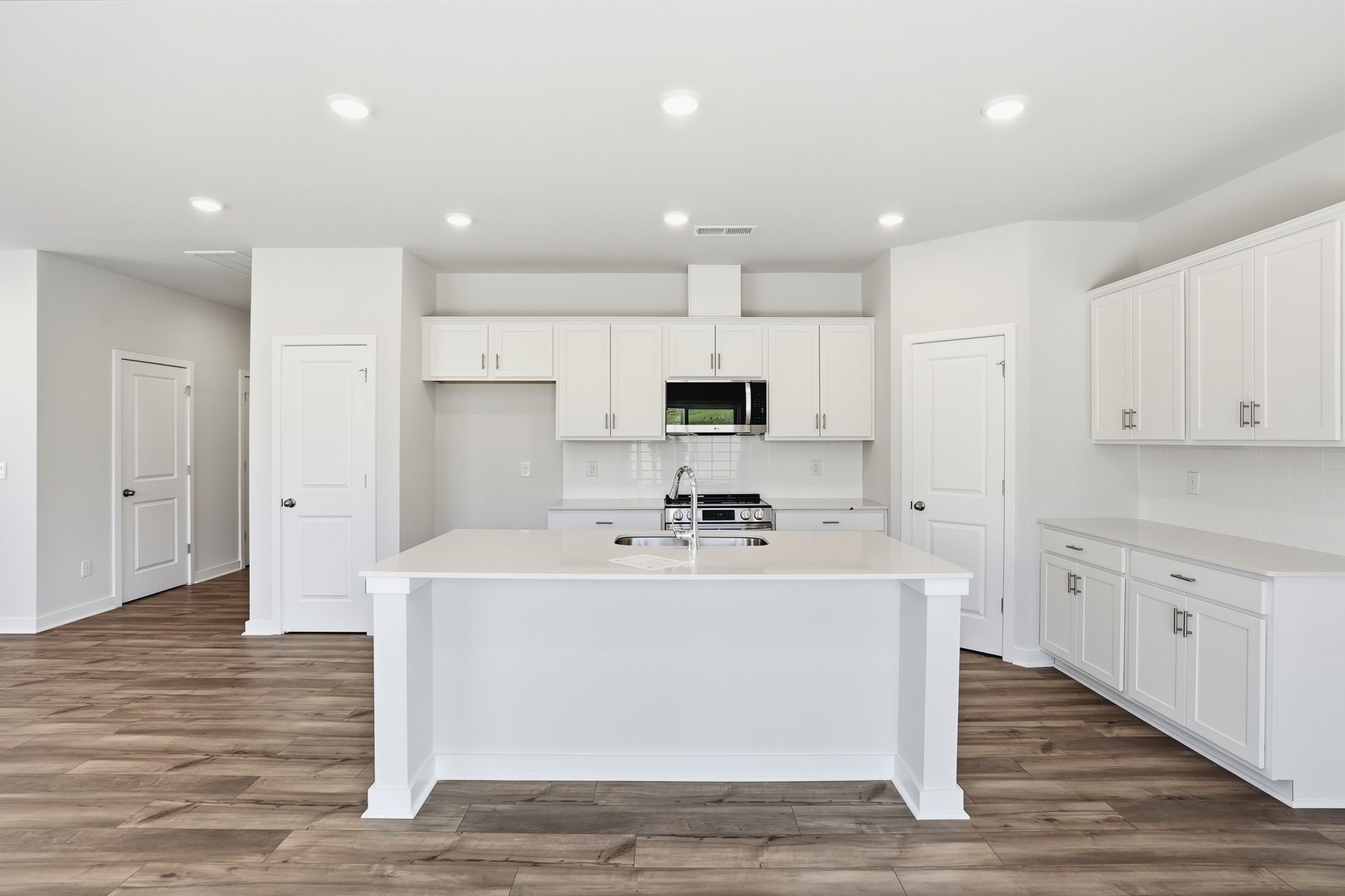 A kitchen with white cabinets.